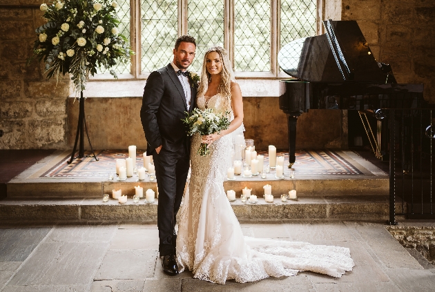 couple on wedding day in castle room next to piano